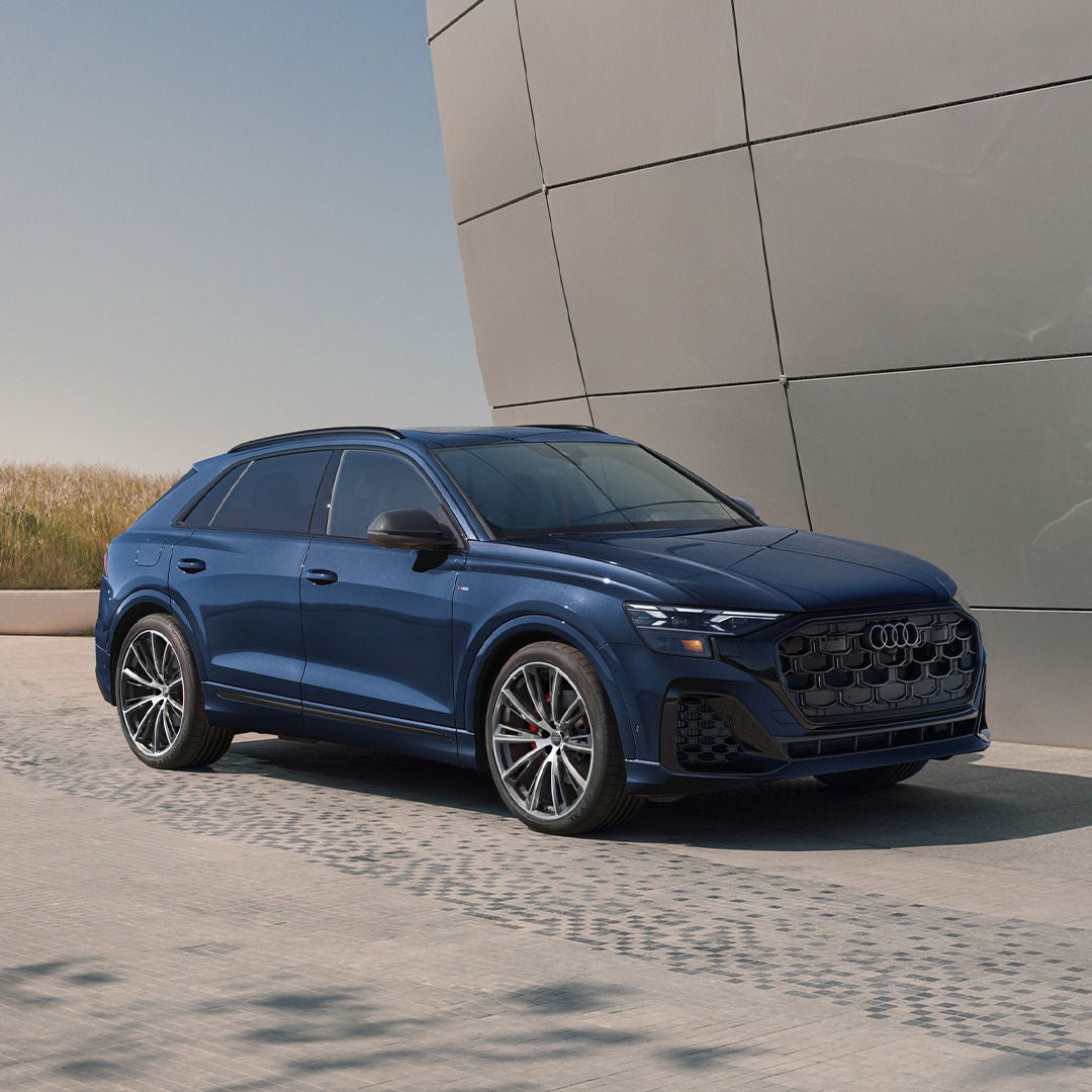 Left side profile view of an Audi Q8 accelerating.